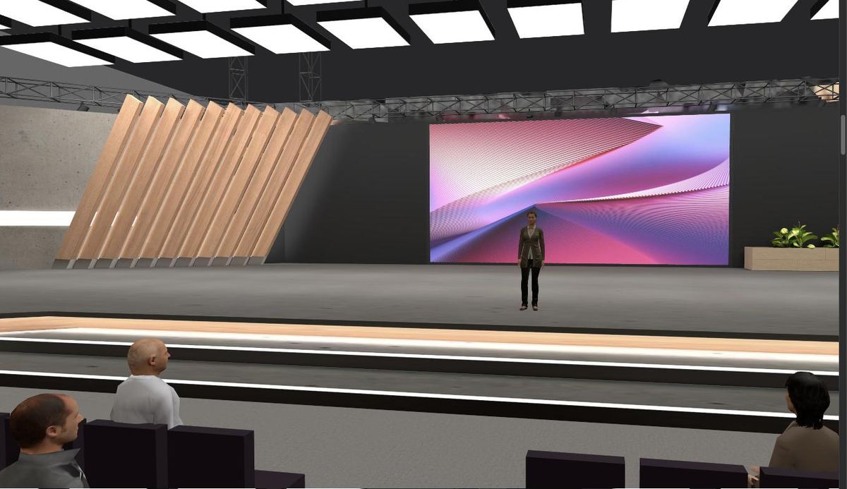 A speaker on stage in a keynote hall, seen from the audience